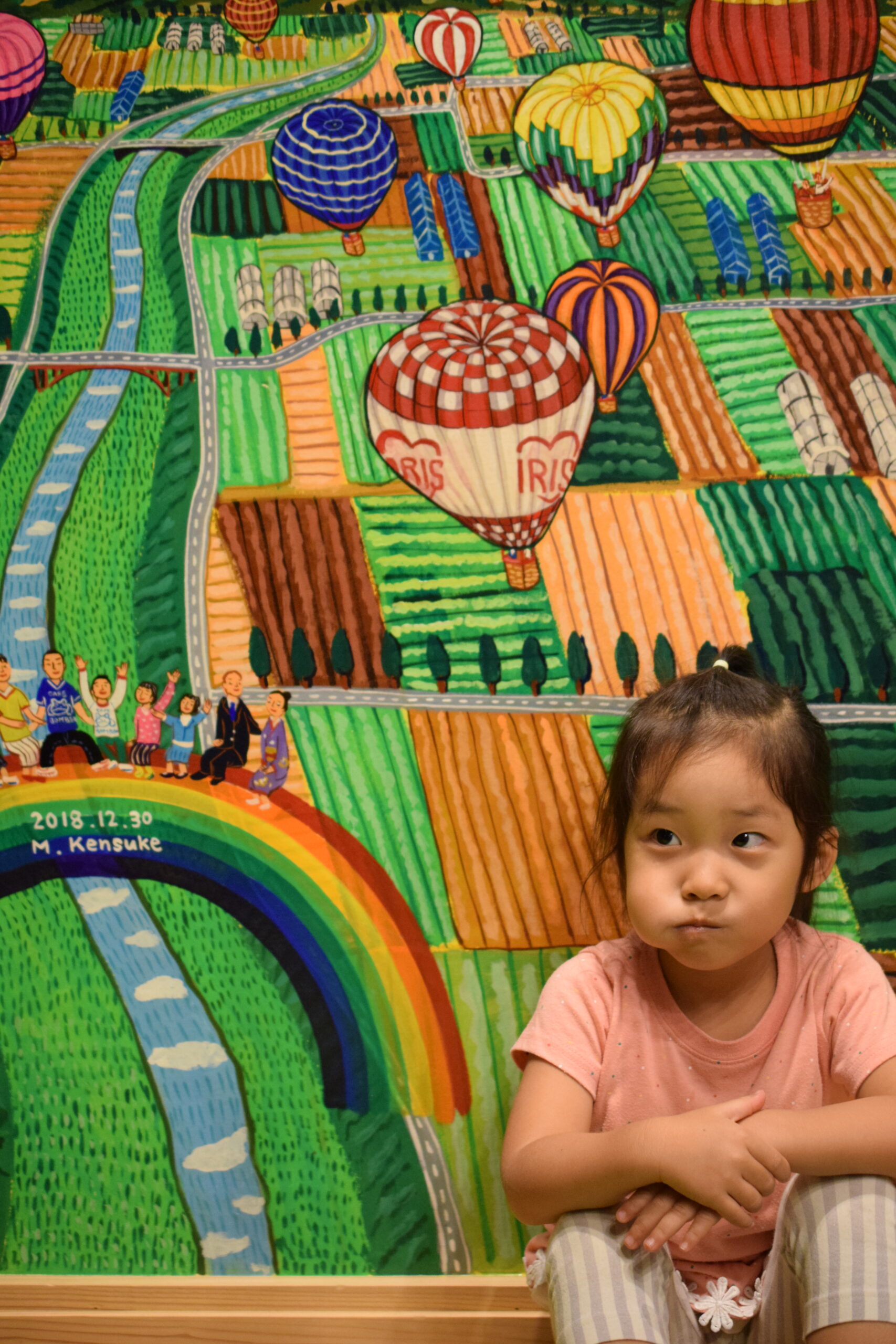 壁画前に座る子供さんイメージ